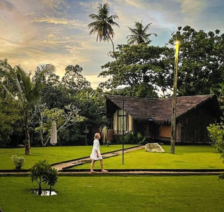 a woman walking in front of a house at Weligama Third Eye Resort in Weligama