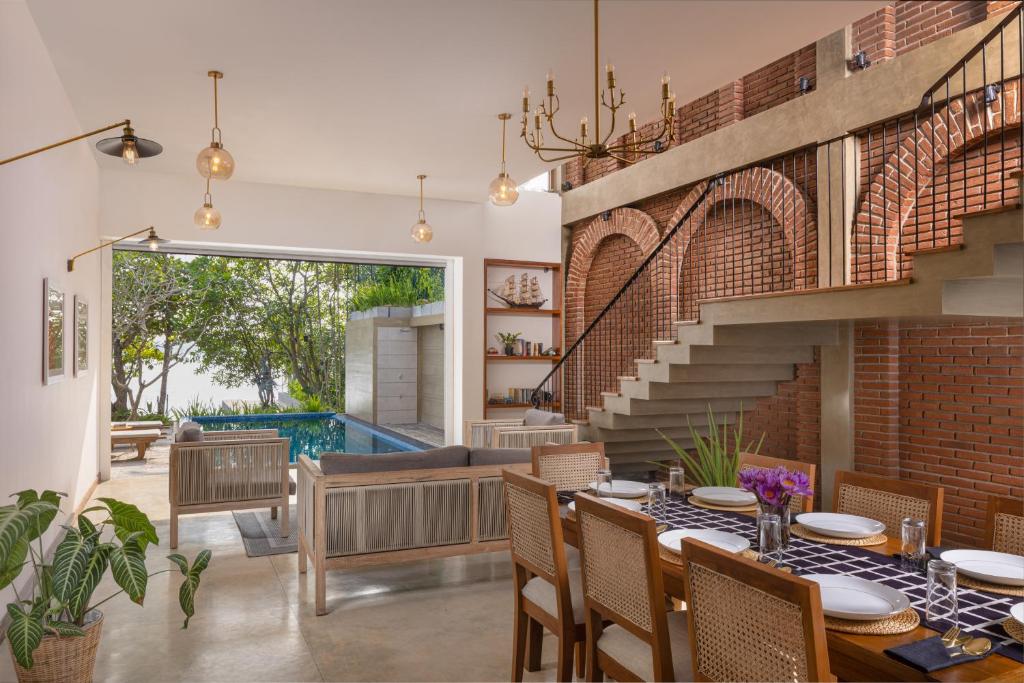 a dining room with a table and a brick wall at Yahva Bentota in Bentota