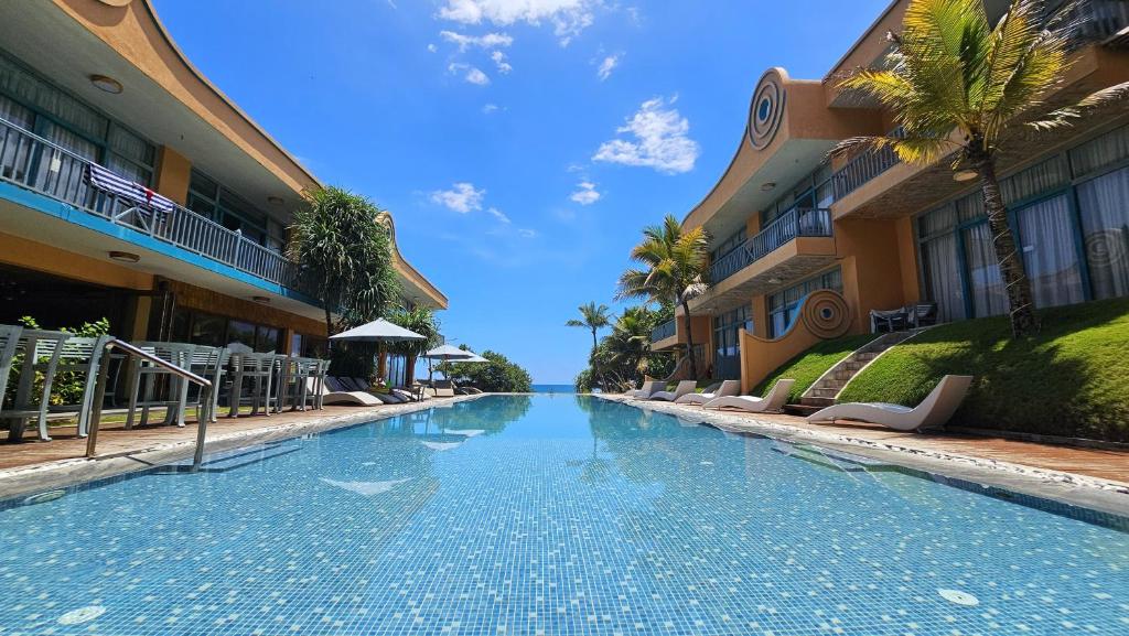 a swimming pool in front of some buildings at Thaproban Pavilion Waves Unawatuna in Unawatuna