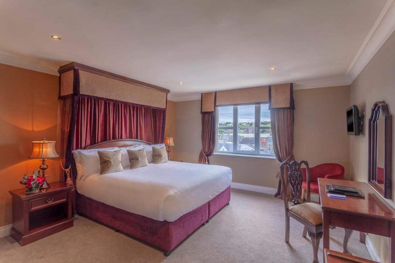 Elegant bedroom with a large bed, rich curtains, and a view of the cityscape.