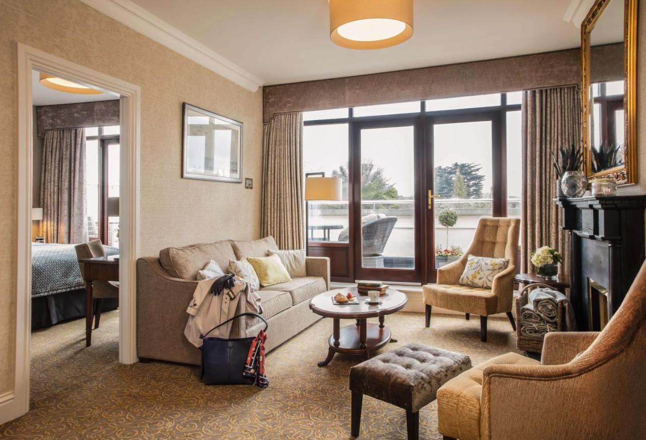 Cozy living room with sofas, chairs, coffee table, and large windows leading to a balcony.