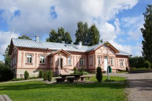 una gran casa rosa con techo de metal en Savonlinnan Kansanopisto - Wanha Pappila en Savonlinna