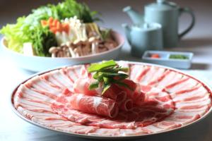 talerz żywności z mięsem i warzywami na stole w obiekcie SHIROYAMA HOTEL kagoshima w mieście Kagoshima