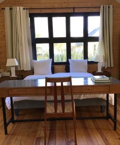 1 dormitorio con mesa, cama y ventana en Clairseine en Tournedos-sur-Seine