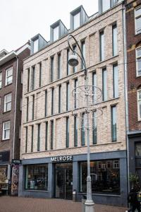 una luz de la calle frente a un gran edificio de ladrillo en Melrose Hotel, en Ámsterdam