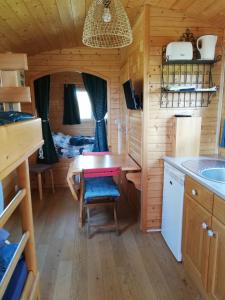 - une petite cuisine avec une table dans une cabane en rondins dans l'établissement Roulot'So Zen, à Beslon
