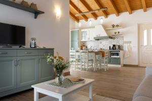 a kitchen and living room with green cabinets and a table at Mos Country House in Tremosine Sul Garda