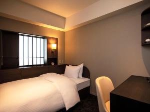 sypialnia z łóżkiem, stołem i oknem w obiekcie SHIROYAMA HOTEL kagoshima w mieście Kagoshima