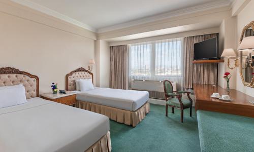 Cette chambre comprend deux lits et une télévision. dans l'établissement Manila Prince Hotel, à Manille