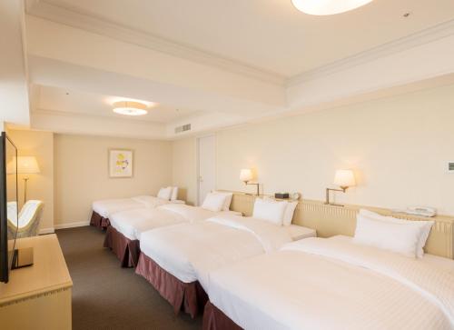 szereg łóżek w pokoju hotelowym w obiekcie SHIROYAMA HOTEL kagoshima w mieście Kagoshima