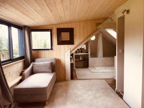 una pequeña sala de estar con sofá y escalera en Clairseine en Tournedos-sur-Seine